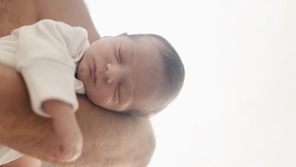 close-up-dad-holding-baby-his-arm